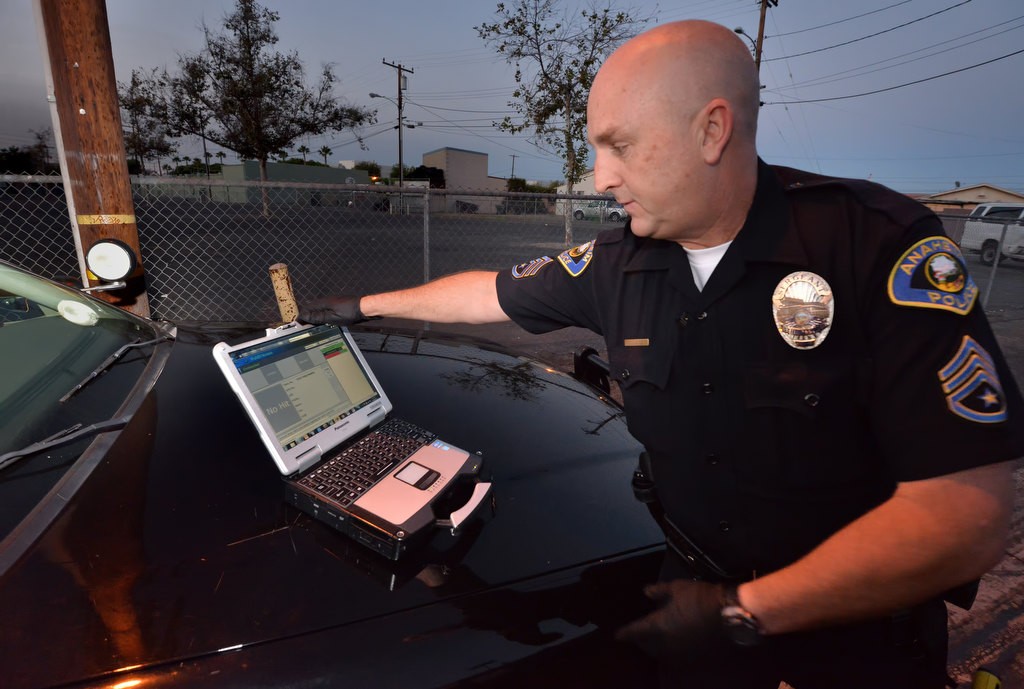 Anaheim PD’s Sgt. Mark Lillemoen uses a custom laptop to send electronic fingerprints back to the office from the hood of his patrol car while still on  location. The fingerprint is then checked against computer databases available to the system. Photo by Steven Georges/Behind the Badge OC