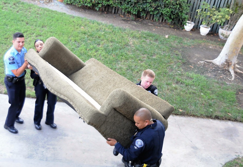  Buena Park police officers and explorers maneuver a bulky, heavy sofa during a volunteer effort to relocate the victims of a burglary from a first-floor to a second-floor apartment. Photo by Lou Ponsi/Behind the Badge OC 