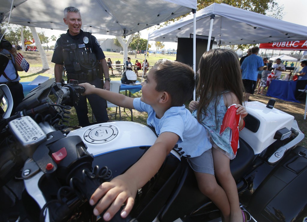 Robbie and Riley Kennedy have a blast while on the bike of Fullerton PD Motor Officer Chris Lefave during the department's National Night Out at Independence Park. Photo by Christine Cotter