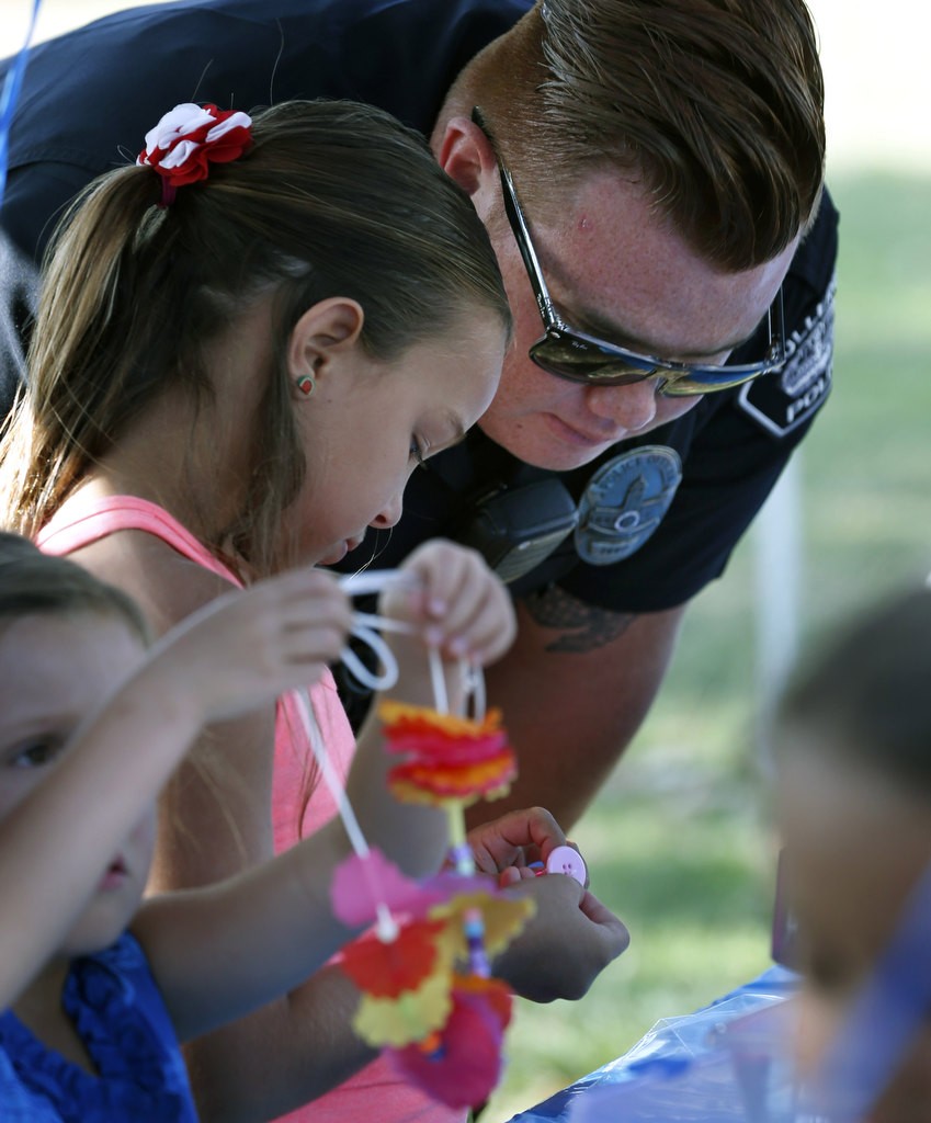 Fullerton PD Officer Jose Paez helps construct a miniature car with Sophia Blake during National Night Out at Independence Park. Photo by Christine Cotter