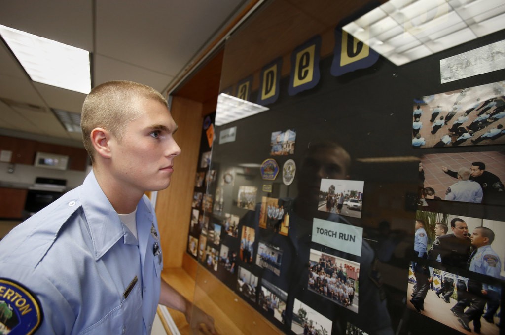 Fullerton PD Cadet Nolan Turner looks over a photo display before a meeting with fellow cadets. Photo by Christine Cotter