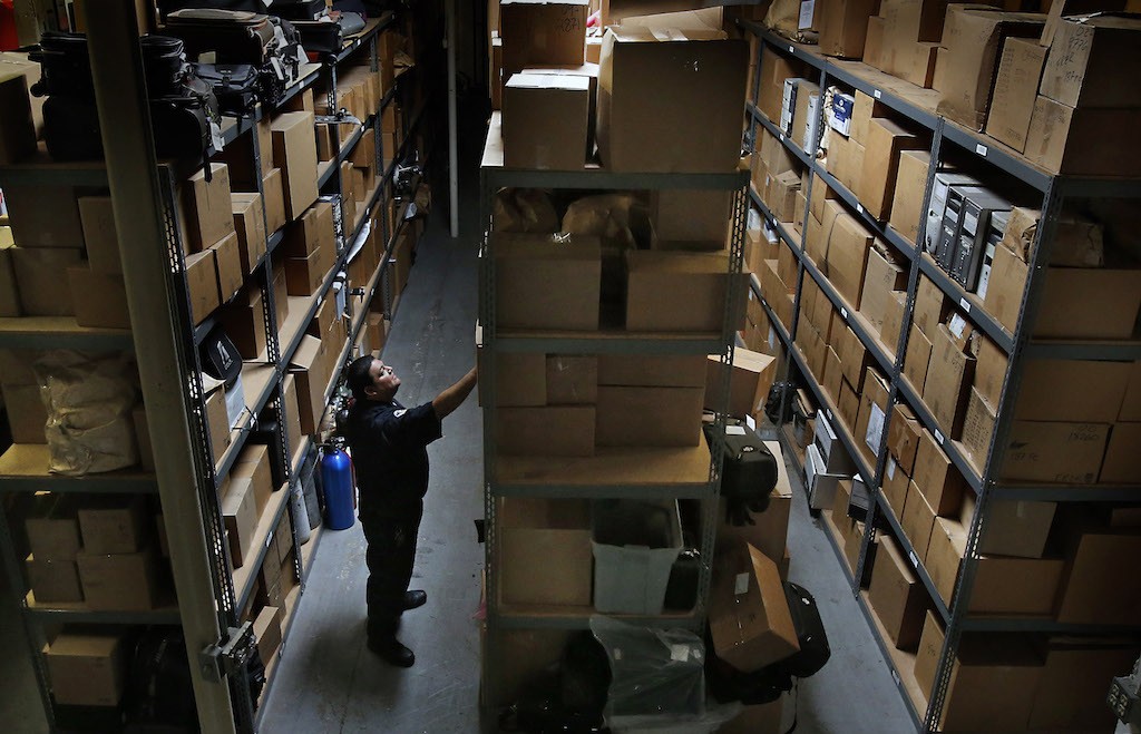 Eric Quintero, senior community services officer for Garden Grove PD, searches through boxes at the department's off-site evidence storage facility. Photo by Christine Cotter
