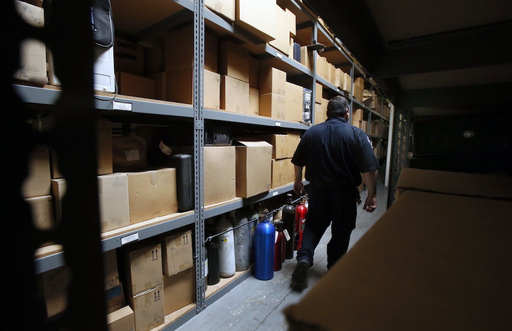 Eric Quintero, senior community services officer for Garden Grove PD, walks past boxes of evidence at the department's off-site evidence storage facility. Photo by Christine Cotter