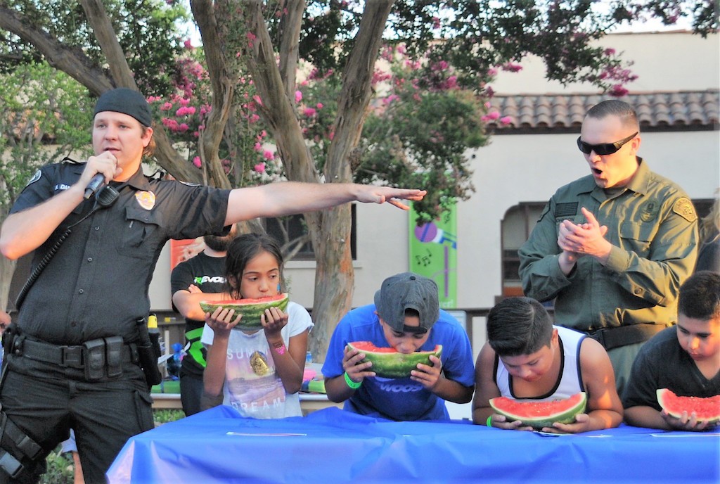 La Habra Police Detective  Daniels, left, and Herb Johnson, right, North County SWAT officer helped oversee the watermelon eating contest, which was among the festivities at La Habra's National Night Out. Photo by Lou Ponsi/Behind the Badge OC. 