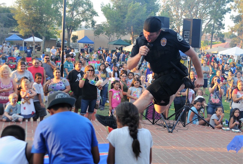 La Habra Detective Daniels got so excited, that he went airborne as he emceed the watermelon eating contest at the National Night Out event. Photo by Lou Ponsi/Behind the Badge OC 