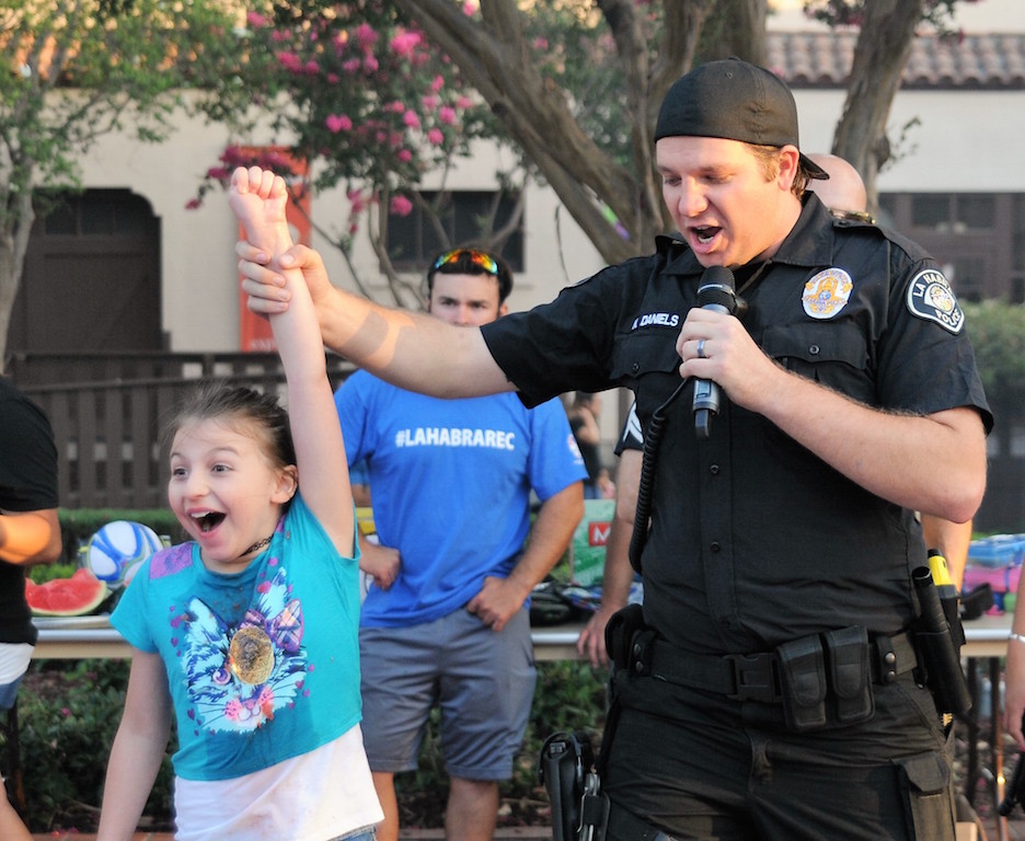 Summer Juarez, 10, was declared the winner of the National Night  Out watermelon eating contest by La Habra PD Detective  Daniels. Photo by Lou Ponsi/Behind the Badge OC. 