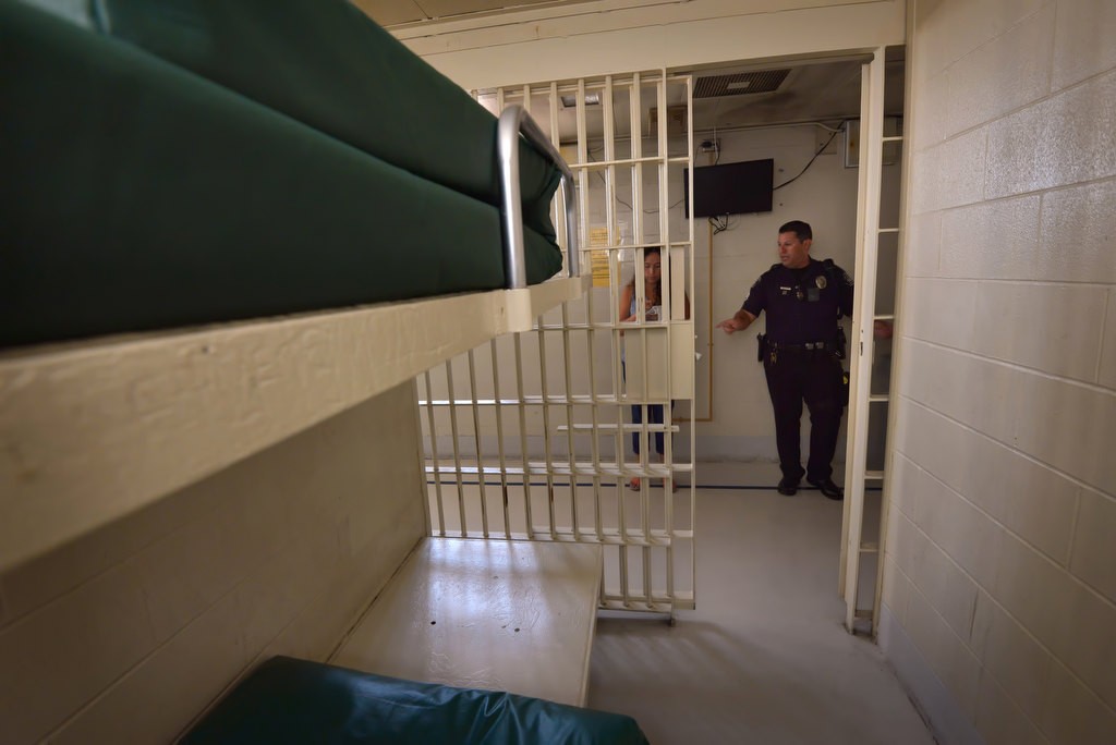 Fullerton PD’s Sgt. Daniel Castillo shows the normal jail cells at the Fullerton PD. A television can be viewed through the bars. Photo by Steven Georges/Behind the Badge OC
