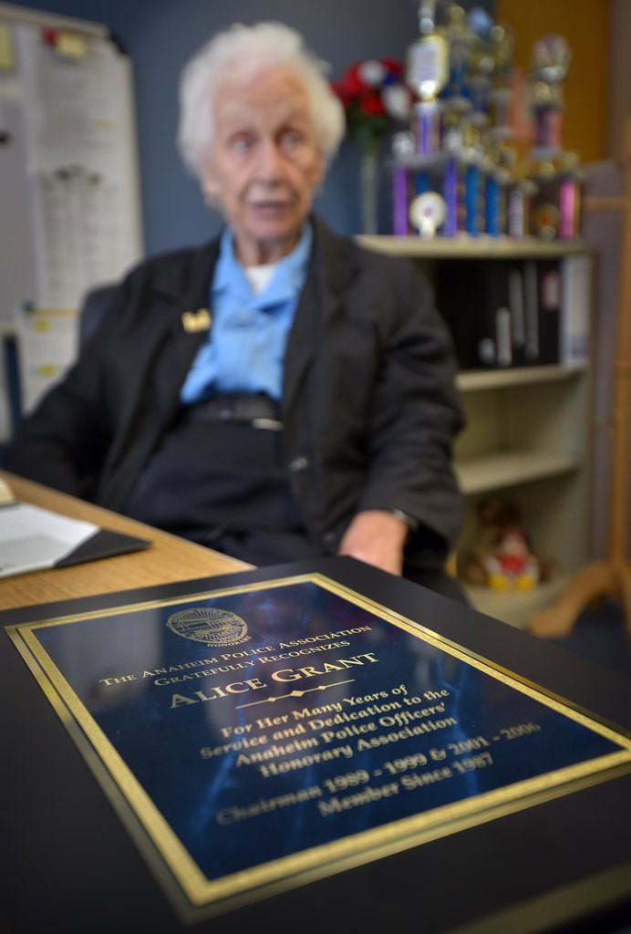 Alice Grant, who's been volunteering at the police station for more than 30 years, with an award she received for her years of service. Photo by Steven Georges/Behind the Badge OC