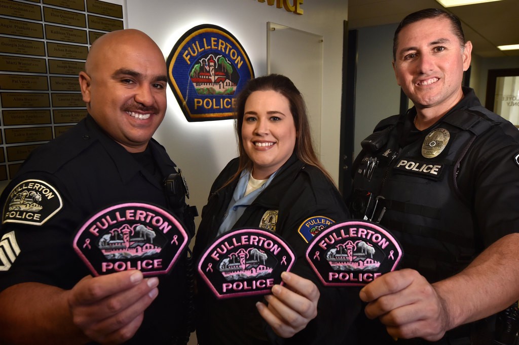 Holding Fullerton Police patches from the Pink Patch Project are from left, Sgt. Jose Arana, Community Service Officer Kristy Wells and Cpl. Jose Flores. Photo by Steven Georges/Behind the Badge OC