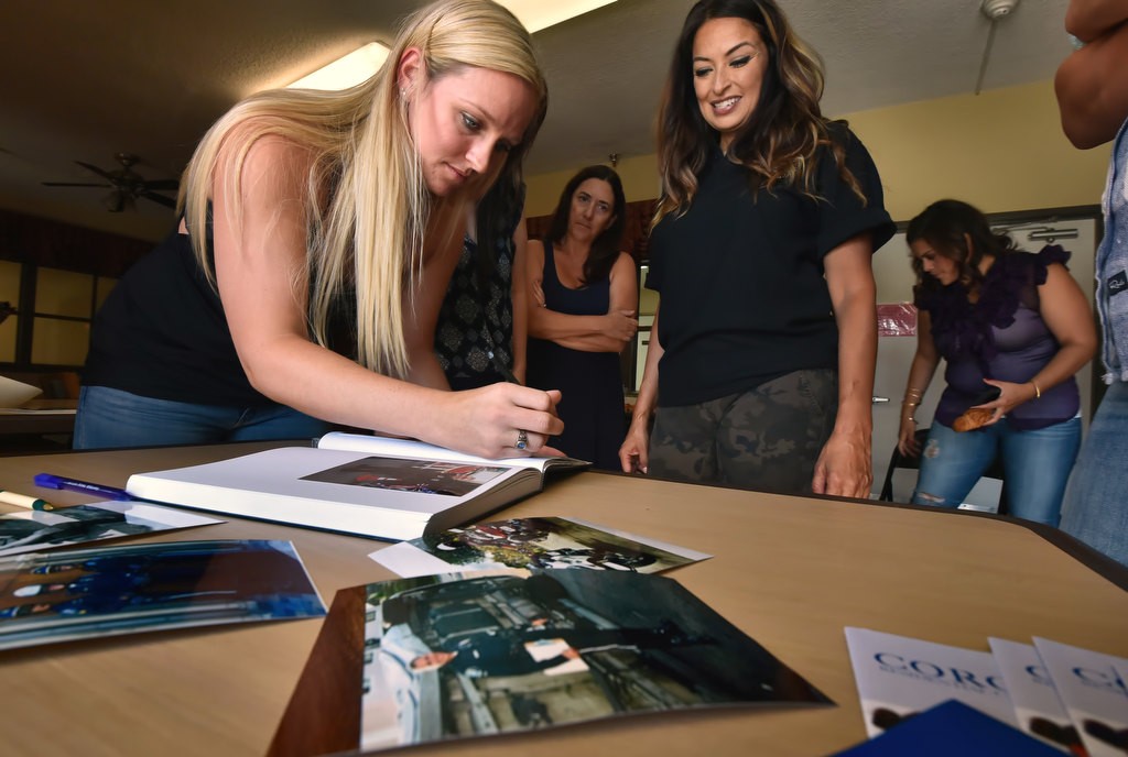 GGPD Officer Vanessa Brodeur, left, puts together a photo scrapbook to give to Alice Chandler with photographs she and the other female officers brought of the themselves on the job. GGPD Officer Katherine Anderson is right. Photo by Steven Georges/Behind the Badge OC