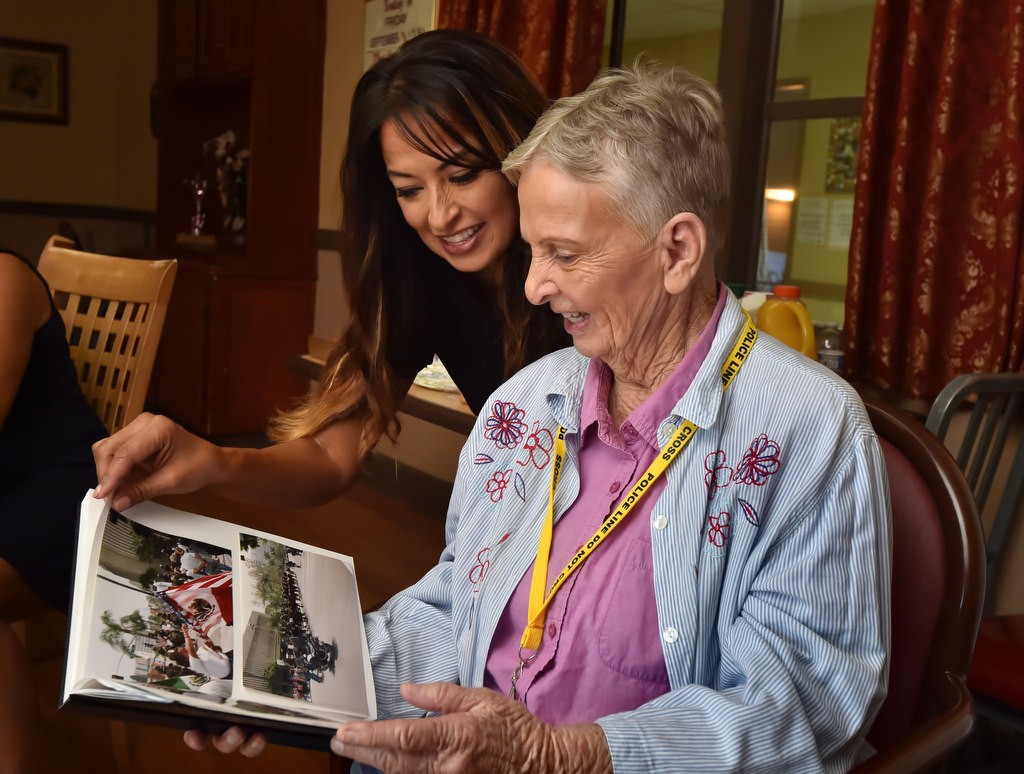 GGPD Motor Officer Katherine Anderson shows Alice Chandler the scrapbook of photographs of female officers on the job they brought to give to Chandler. Photo by Steven Georges/Behind the Badge OC
