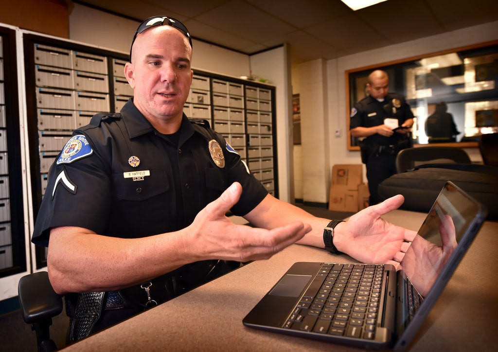 Garden Grove PD Officer Brian Hatfield works on a report with the new tablet/keyboard portable computer system in the briefing room at police headquarters. Photo by Steven Georges/Behind the Badge OC