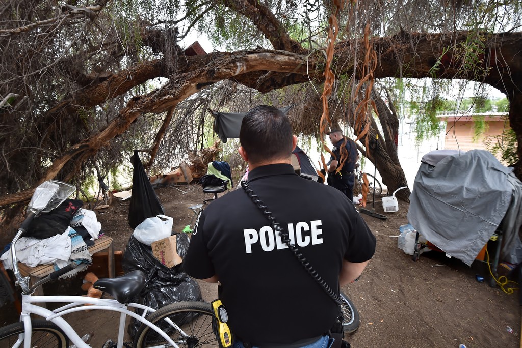 La Habra PD Officer Daniel Uberin checks in on a homeless camp in La Habra. Photo by Steven Georges/Behind the Badge OC