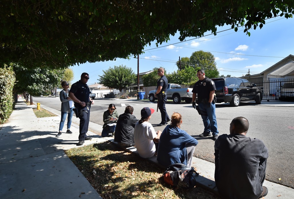 La Habra police officers talks with a group of transients on Erna Avenue. in La Habra. Photo by Steven Georges/Behind the Badge OC