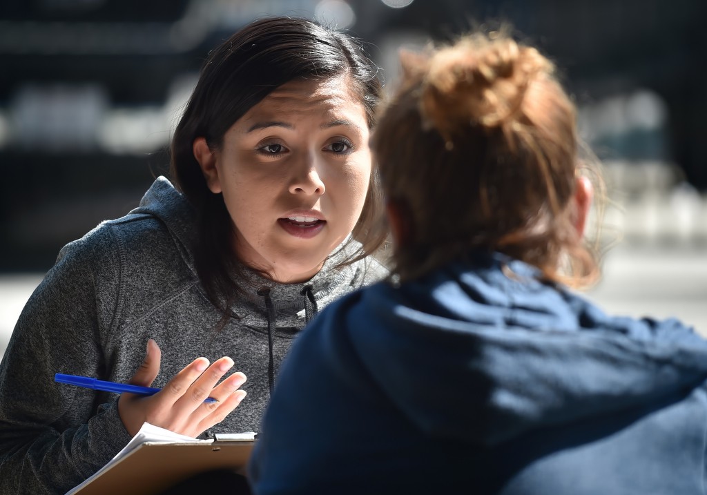 Marissa Uribe, intern (Cal State Fullerton) for City Net talks to a women during a homeless outreach visit. Photo by Steven Georges/Behind the Badge OC