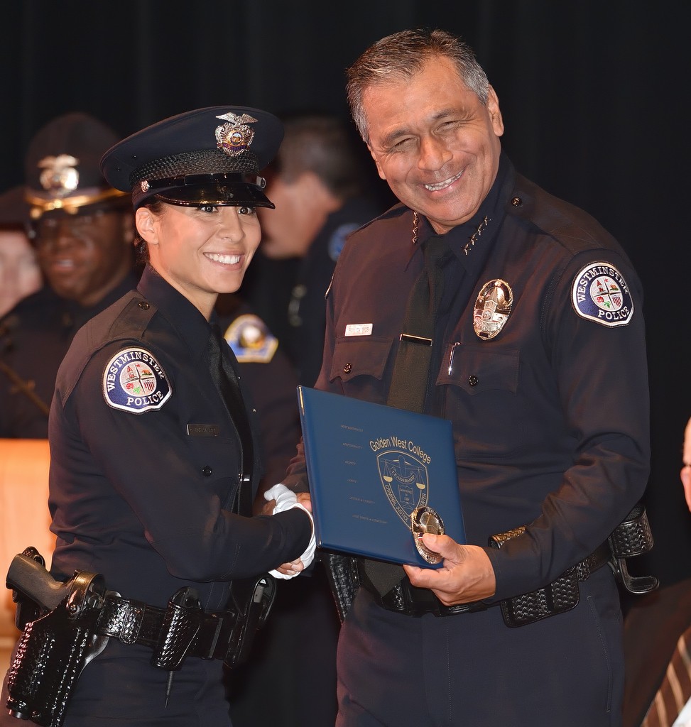 Westminster PD Interim Police Chief Roy Campos, right, presents recruit Frani Echavarria with her basic police academy diploma during Golden West College Criminal Justice Training Center's graduation ceremony. Photo by Steven Georges/Behind the Badge OC