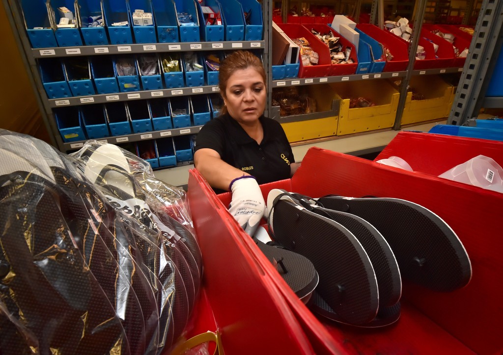 OCSD's Maria Robles grabs a pair of extra large shower shoes that an Orange County inmate ordered. Photo by Steven Georges/Behind the Badge OC