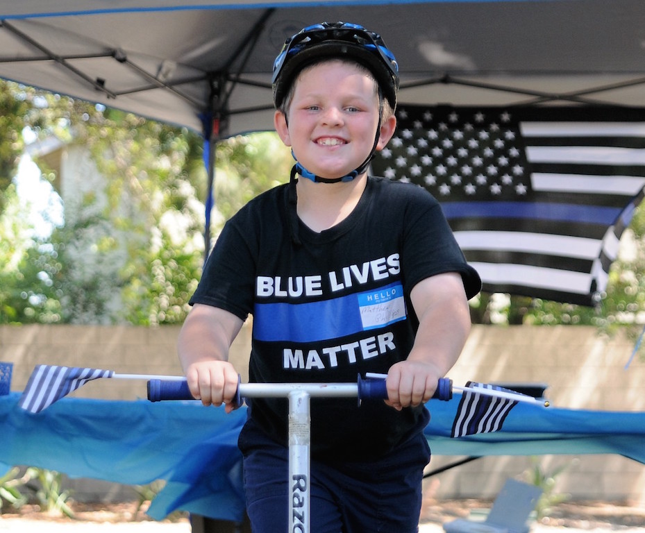Matthew Phillips, 8, came to Centennial Park in Tustin all the way from Porterville shows his support for law enforcement during a meet-and-greet organized by a Valerie Mann, founder of a pro-police Facebook page. 