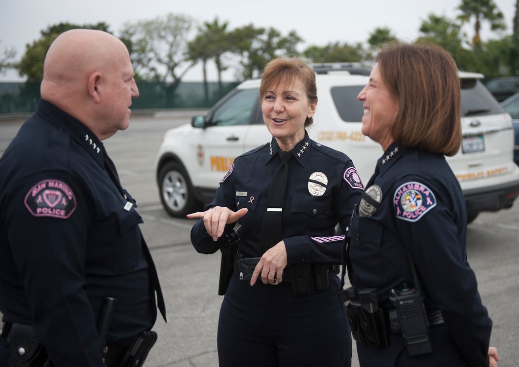 San Marino Chief John Incontro, left, chats with Hermosa Beach Chief Sharon Papa and Alhambra Interim Chief Jackie Gomez-Whiteley before the photo shoot. About 40 Police Chiefs from various agencies in the state at Dodger Stadium to participate in the Pink Patch Project group photo.