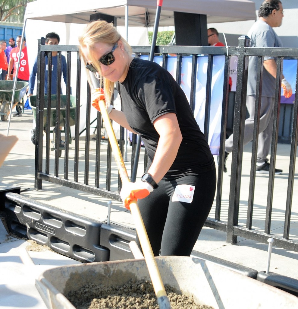 OCSD Deputy Kaylynn Cramer smooths out freshly poured cement during the playground building project. Photo by Lou Ponsi/Behind the Badge OC