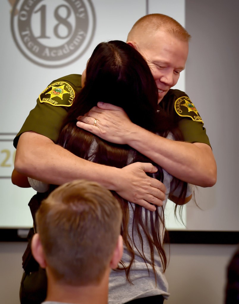 OCSD Commander Bob Peterson gets a hug from one of the Youth Citizens’ Academy graduates after admitting that she now has a new respect for law enforcement officers after going through the program. Photo by Steven Georges/Behind the Badge OC