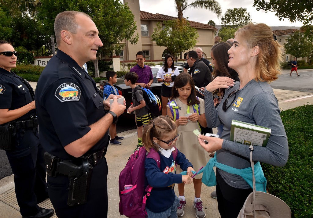 Tracy Shone, a Tustin resident who moved from the Cayman Islands a little over a year ago, talks to Tustin Police Chief Charles Celano as kids from Peters Canyon Elementary School gather to walk to school with the Tustin PD. Photo by Steven Georges/Behind the Badge OC