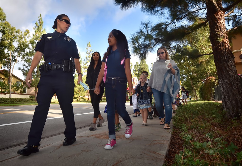 Tustin PD Officer Melissa Trahan walks with students down Pioneer Road on their way to Peters Canyon Elementary School in Tustin. Photo by Steven Georges/Behind the Badge OC