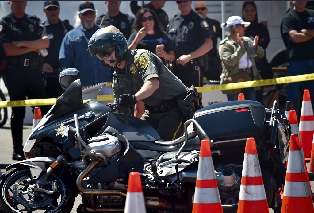 OCSDÕs Eric Gooselaw smiles as he tips his motorcycle, a common occurrence during the OCTOA competition. Photo by Steven Georges/Behind the Badge OC