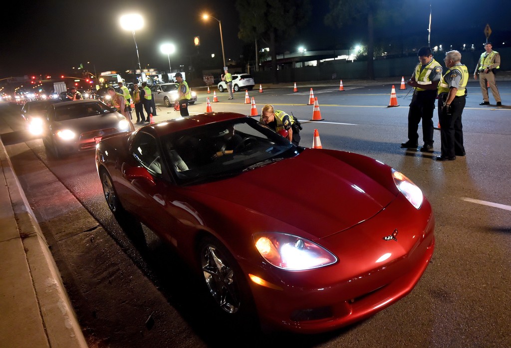 Tustin PD Officer Bonnie Breeze talks to a driver in a Corvette stopped at a DUI checkpoint. Photo by Steven Georges/Behind the Badge OC