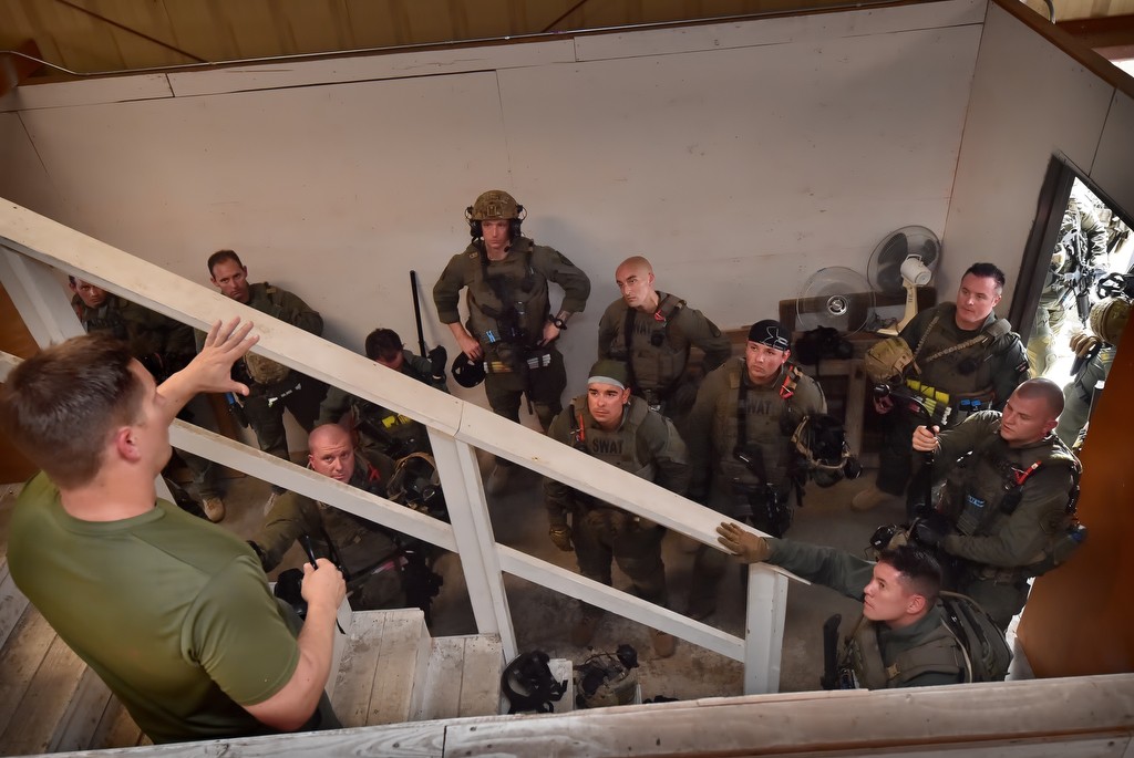 North County SWAT officers review their tactics at the end of each drill. Catwalks are built above the walls so their command staff can view their performance from above. Photo by Steven Georges/Behind the Badge OC