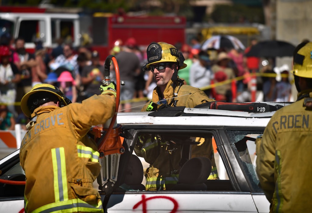 Garden Grove Firefighter Corey Lindsay, center, uses the jaws of life as he works with other Garden Grove firefighters for a car rescue demonstration during Fire Service Day 2016 at the North Net Fire Training Center in Anaheim. Photo by Steven Georges/Behind the Badge OC