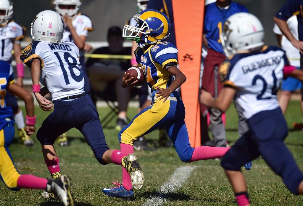 Bruce Whitley (24) of the Anaheim Rams runs with the ball for a touchdown during a Pop Warner football game at Brookhurst Community Park in Anaheim. Photo by Steven Georges/Behind the Badge OC