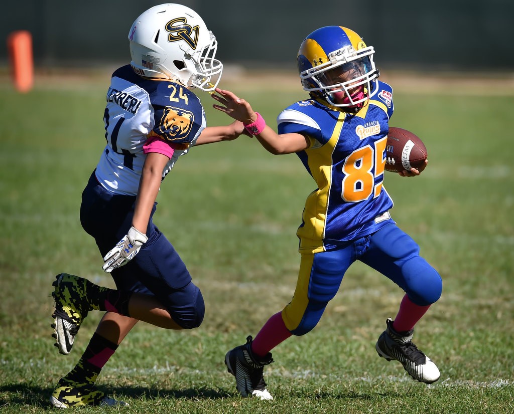 Ruben Mendez (85) of the Anaheim Rams runs with the ball during a Pop Warner football game at Brookhurst Community Park in Anaheim. Photo by Steven Georges/Behind the Badge OC