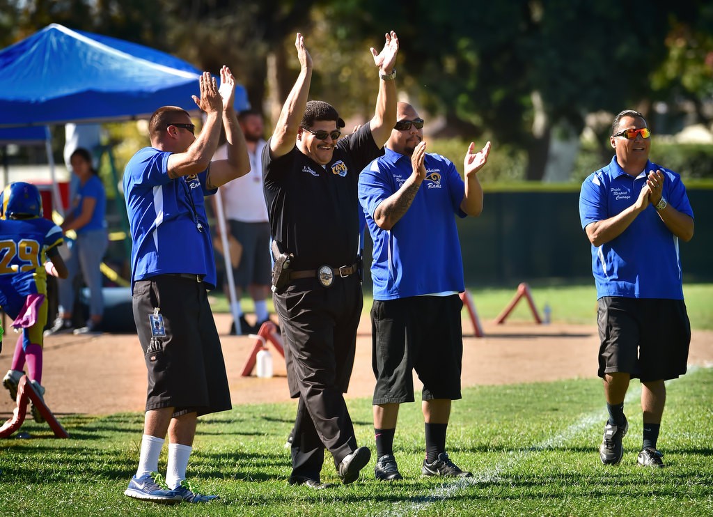 Anaheim PD Officer Eddie Fletcher cheers with the other coaches of the Anaheim Rams after an important play during a Pop Warner football game at Brookhurst Community Park in Anaheim. Photo by Steven Georges/Behind the Badge OC