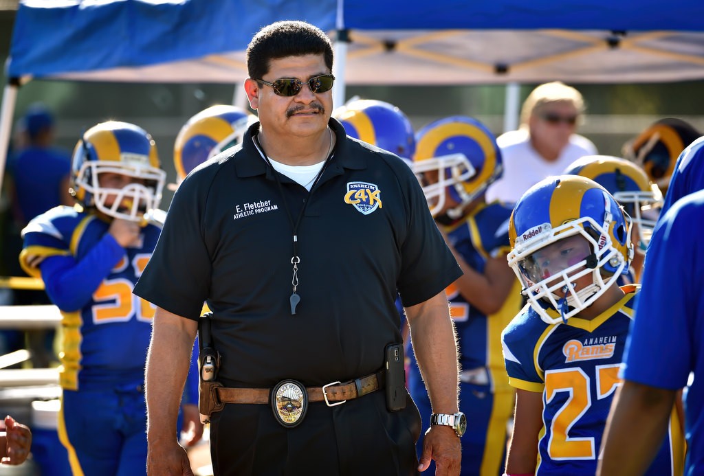 Anaheim PD Officer Eddie Fletcher, one of the coaches for the Anaheim Rams, stays with his team during a Pop Warner football game. Photo by Steven Georges/Behind the Badge OC