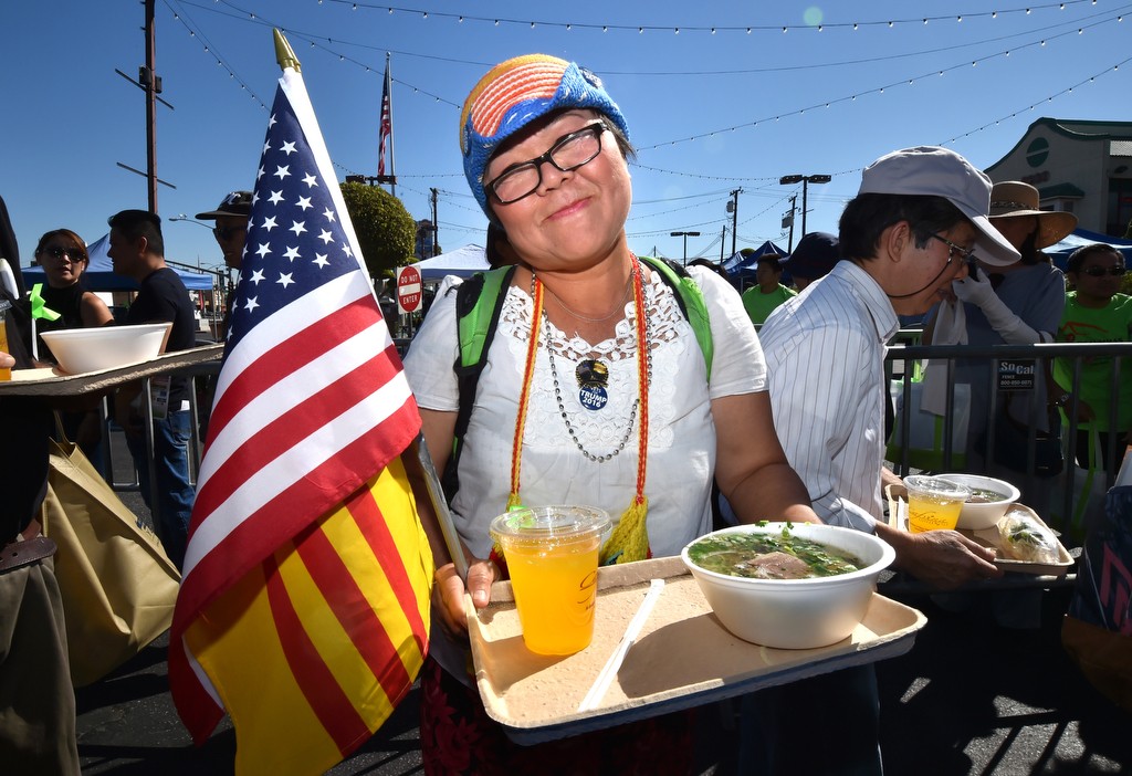 Victoria Kim, who became United States citizen two years ago, smiles with her free bowl of Pho (a type of Vietnamese soup) served to her by the Westminster and Garden Grove PD during the Viet-CARE Pho-Covery Celebration at the Asian Garden Mall in Westminster. Photo by Steven Georges/Behind the Badge OC