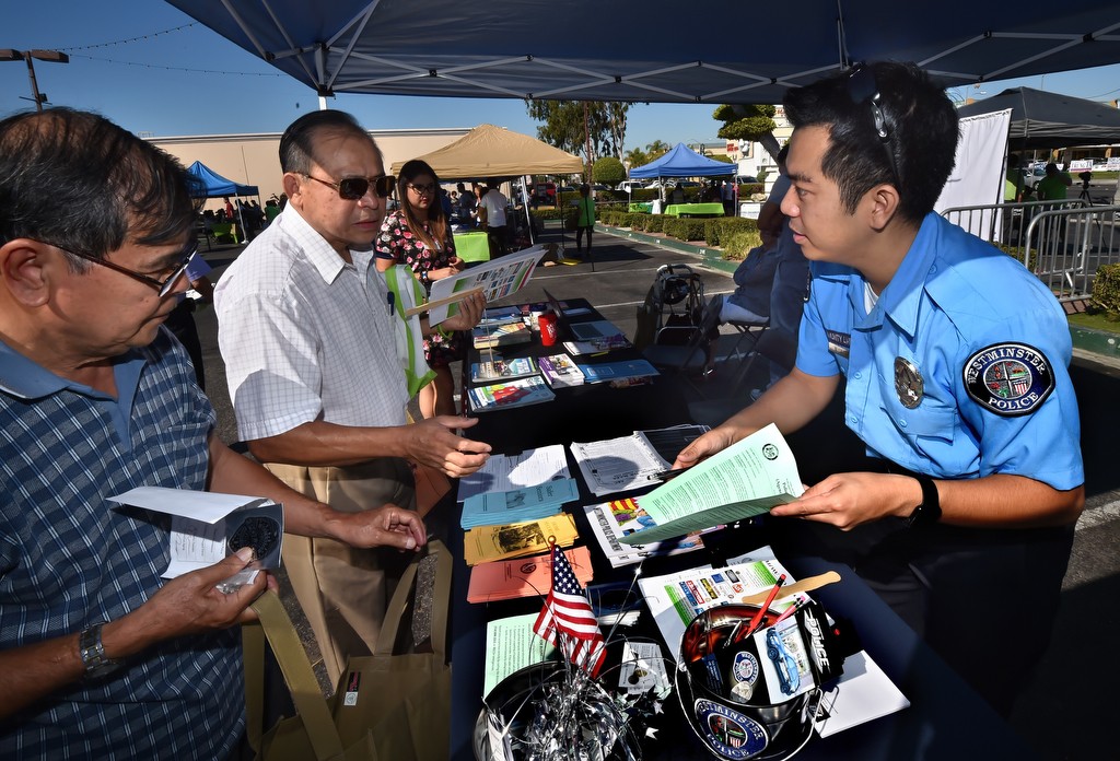 Billy Le, community liaison with the Westminster PD, right, hands out information on public safety and other issues  during the Viet-CARE Pho-Covery Celebration at the Asian Garden Mall in Westminster. Photo by Steven Georges/Behind the Badge OC