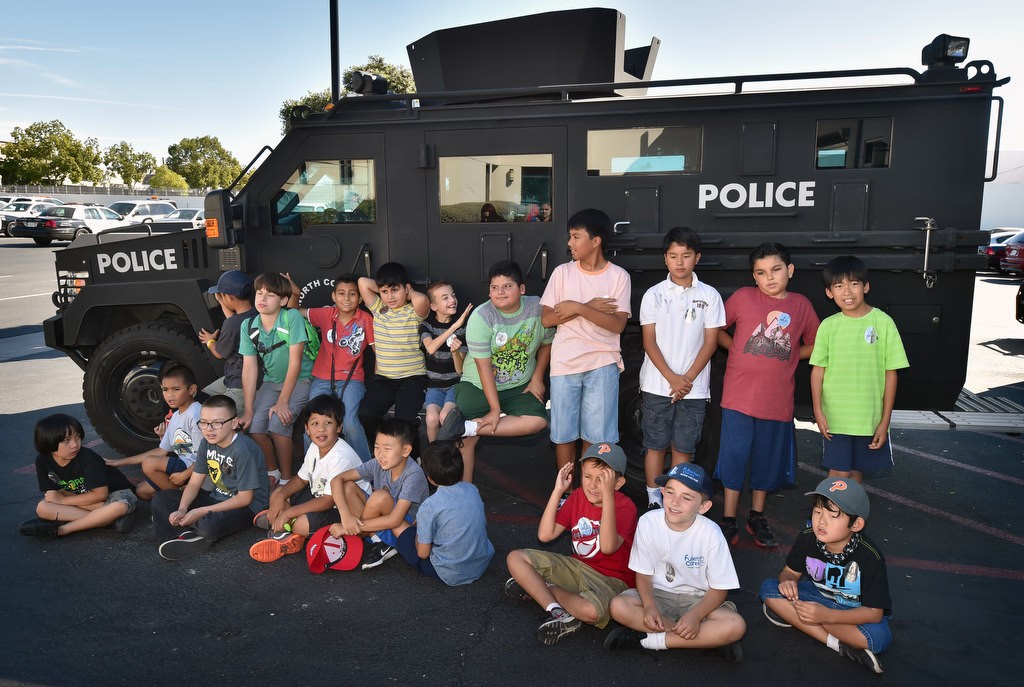 Autistic kids from Golden Hill Elementary School in Fullerton sit in front of a BearCat SWAT vehicle during a tour of the Fullerton Police Station. Photo by Steven Georges/Behind the Badge OC