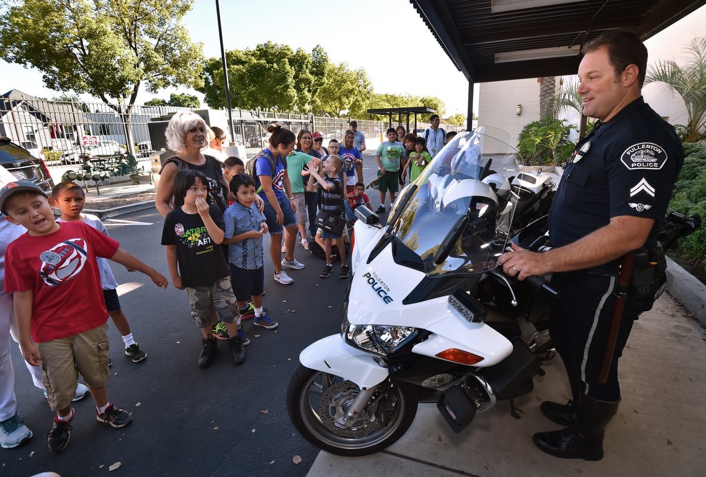 Fullerton PD Cpl. Stephen Bailor talks to the kids from Golden Hill Elementary School in Fullerton about riding a police motorcycle during a tour of the police station. Photo by Steven Georges/Behind the Badge OC