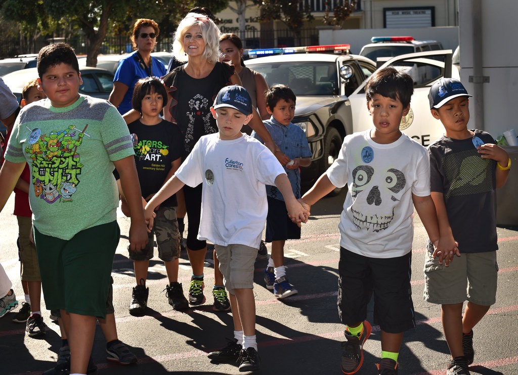 Autistic kids from Golden Hill Elementary School hold hands as they walk through police headquarters during a tour of the Fullerton Police Station. Photo by Steven Georges/Behind the Badge OC