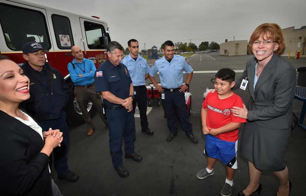 Linda Wagner, school superintendent for Anaheim Elementary School District, right, with 9-year-old Carlos Bermejo, who’s home was affected by the apartment complex fire last November, as the Anaheim Fire Department visits Edison Elementary School in Anaheim. Photo by Steven Georges/Behind the Badge OC