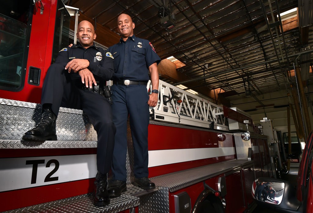 Lt. Lorenzo Glenn of Anaheim PD, left, with his brother Capt. Tariq Ahmad of Anaheim Fire & Rescue on a fire truck at Anaheim Fire Station 2.Photo by Steven Georges/Behind the Badge OC