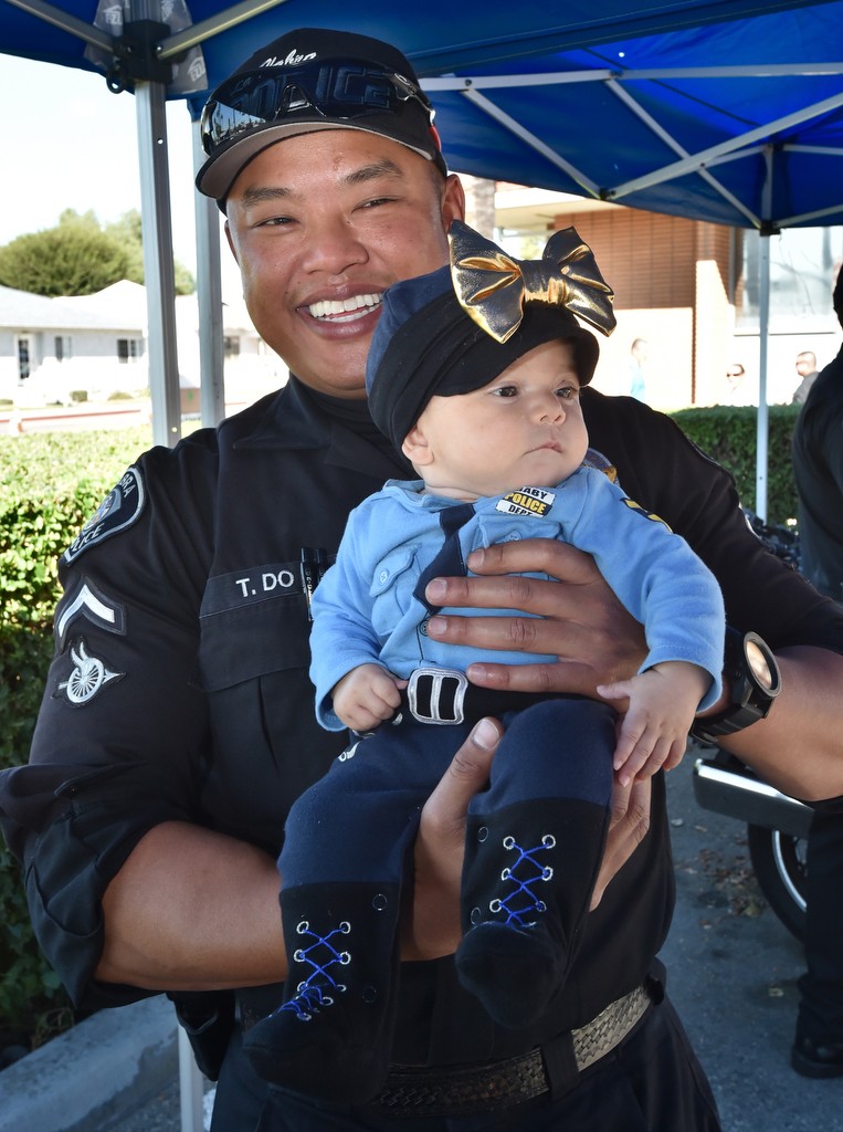 La Habra Motor Officer Tam Do holds 5-month-old Rosebella Osuna who had her own police uniform on during LHPD’s open house. Photo by Steven Georges/Behind the Badge OC