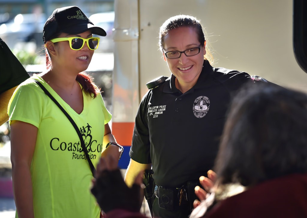 Marie Avena, founder of Coast to Coast Foundation, left, and Fullerton PD Homeless Liaison Cpl. Ginny Johnson check on Philip, a homeless man in Fullerton, during a visit to the OCTA Bus Stop in Fullerton. Photo by Steven Georges/Behind the Badge OC