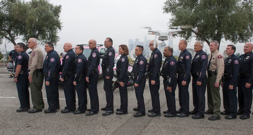 About 40 police chiefs from various agencies in the state pose as a drone camera flies by at Dodger Stadium.  The group is participating in the Pink Patch Project during Breast Cancer Awareness Month.