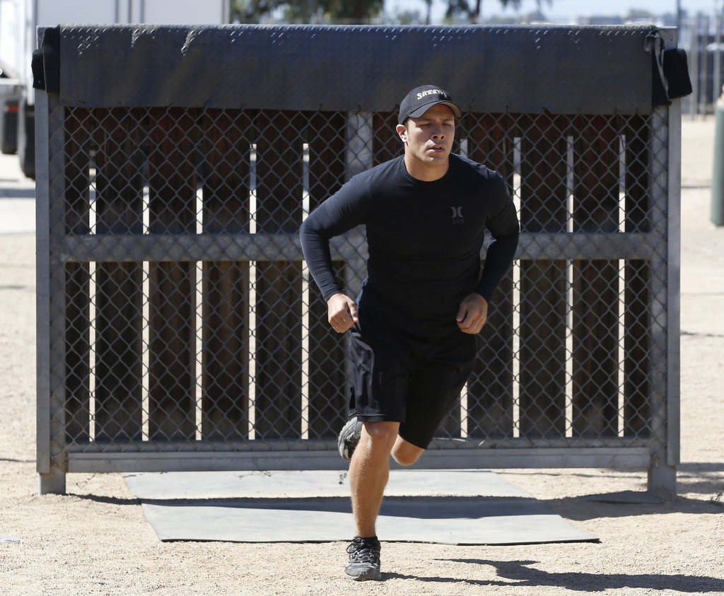 Orange County Sheriff's Deputy Mike Duran runs the obstacle course during a physical agility test demonstration at the OCSD Career Fair in Tustin. Photo by Christine Cotter
