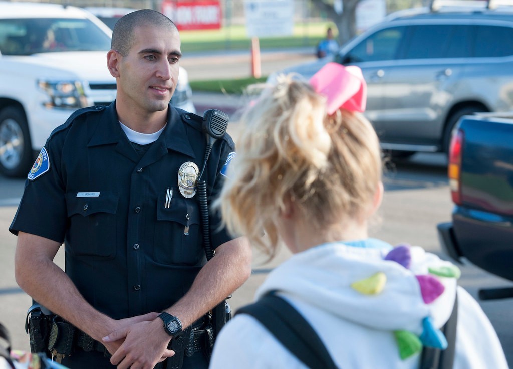 Garden Grove Police Officer Josh Behzad talks with students from Bell Intermediate School before the start of class while participating in National Walk to School Day.