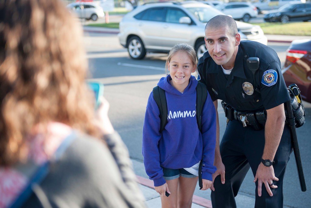 Garden Grove Police Officer Josh Behzad poses for a photo with a student from Bell Intermediate School before the start of class while participating in National Walk to School Day.