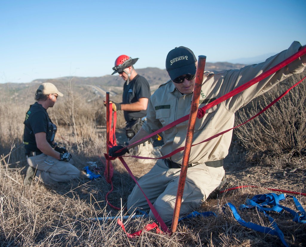 Members of the Orange County Sheriff's Search and Rescue Team PSR Shawn Crawford, left, PSR Eric Klingsporn and PSR Brian Clark set up an anchor as part of a demonstration of the process of finding a lost subject in the Aliso Woods Wilderness Park.