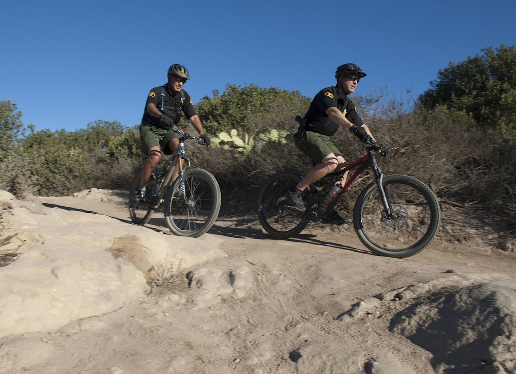 Members of the Orange County Sheriff's Search and Rescue Team Deputy Gary Ziebarth, left, and Reserve Lieutenant. Devon Kemp demonstrate the process of finding a lost subject on mountain Bikes in the Aliso Woods Wilderness Park.  The bikes allow for a quiet but quick search that allows them to hear responsive people off trail or a non responsive person on a trail.